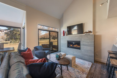 Diseño de salón abierto minimalista de tamaño medio con chimenea lineal, marco de chimenea de baldosas y/o azulejos, televisor colgado en la pared y suelo gris