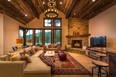 Foto de salón cerrado rústico grande con paredes beige, suelo de madera clara, chimenea de esquina, marco de chimenea de piedra y televisor independiente