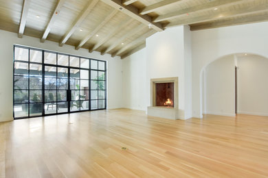 オースティンにある高級な広いトランジショナルスタイルのおしゃれなLDK (白い壁、淡色無垢フローリング、標準型暖炉、石材の暖炉まわり、ベージュの床) の写真