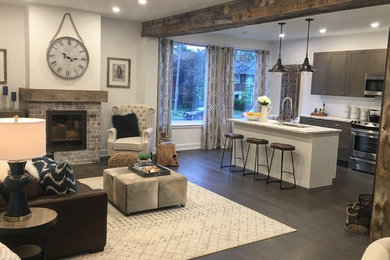 Inspiration for a mid-sized rustic open concept laminate floor and brown floor living room remodel in Ottawa with white walls, a standard fireplace, a brick fireplace and no tv