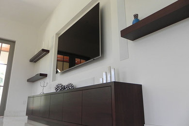 Immagine di un piccolo soggiorno design chiuso con pareti bianche, pavimento in laminato, nessun camino e TV a parete
