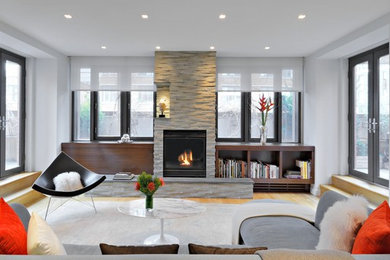 Contemporary living room in New York with medium hardwood flooring, a standard fireplace and a stone fireplace surround.