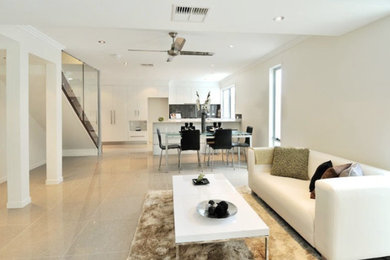 Photo of a large modern open plan living room in Brisbane with white walls and porcelain flooring.