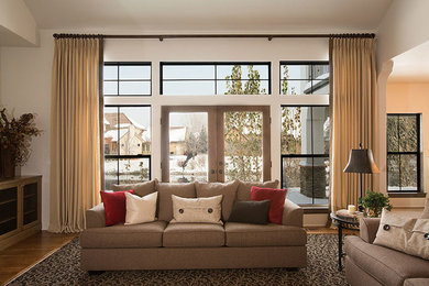 Immagine di un grande soggiorno chic aperto con pareti bianche, pavimento in legno massello medio e nessuna TV