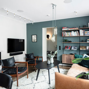 Inspiration för ett stort skandinaviskt allrum med öppen planlösning, med blå väggar, mörkt trägolv, en standard öppen spis, en spiselkrans i gips, en väggmonterad TV och brunt golv