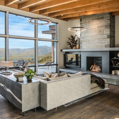 Example of a large trendy open concept medium tone wood floor, brown floor and wood ceiling living room design in Other with white walls, a standard fireplace, a metal fireplace and a wall-mounted tv