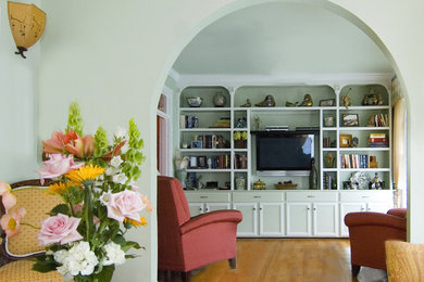 Diseño de biblioteca en casa cerrada clásica con televisor colgado en la pared y arcos