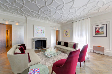 Ejemplo de salón para visitas cerrado minimalista grande con paredes beige, suelo de madera clara, todas las chimeneas y marco de chimenea de piedra