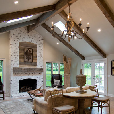 Inspiration for a large cottage formal and open concept medium tone wood floor and brown floor living room remodel in Kansas City with gray walls, a standard fireplace and a stone fireplace