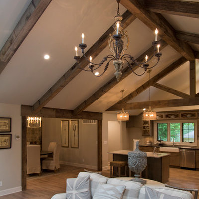 Large cottage formal and open concept medium tone wood floor and brown floor living room photo in Kansas City with gray walls, a standard fireplace and a stone fireplace