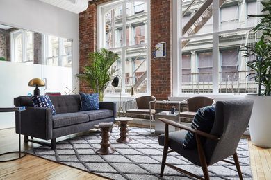 Inspiration for a large industrial loft-style light wood floor living room remodel in New York with no tv