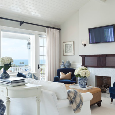 Inspiration for a mid-sized coastal formal and open concept carpeted living room remodel in Los Angeles with gray walls, a standard fireplace, a wood fireplace surround and a wall-mounted tv