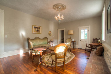 Ejemplo de salón para visitas cerrado romántico grande sin chimenea y televisor con paredes grises, suelo de madera en tonos medios y suelo marrón