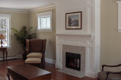 Exemple d'un salon chic de taille moyenne et fermé avec un mur beige, un sol en bois brun, une cheminée standard, un manteau de cheminée en carrelage, aucun téléviseur et un sol marron.