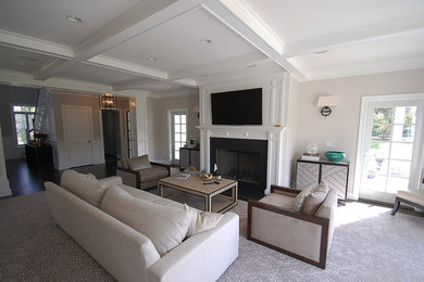 Idee per un soggiorno chic di medie dimensioni con pareti beige, moquette, camino classico, cornice del camino in metallo e TV a parete
