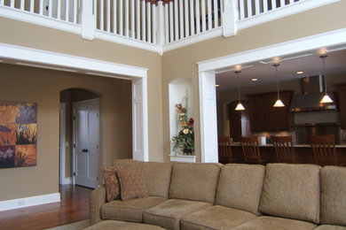 Imagen de salón abierto clásico grande con paredes beige y suelo de madera en tonos medios