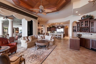 Living room - large mediterranean open concept travertine floor living room idea in Miami with a bar, beige walls, no fireplace and no tv