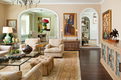 Modelo de salón cerrado clásico grande sin chimenea y televisor con paredes beige, suelo de madera oscura, suelo marrón y arcos