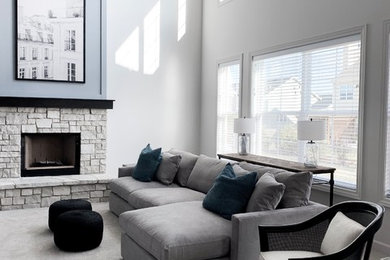 シカゴにある高級な中くらいなトランジショナルスタイルのおしゃれなLDK (白い壁、カーペット敷き、標準型暖炉、石材の暖炉まわり、壁掛け型テレビ、グレーの床) の写真