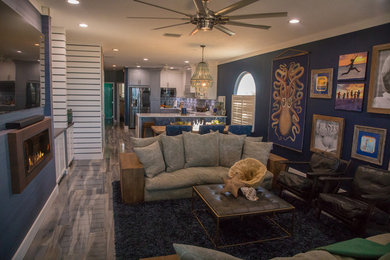 Large beach style open concept ceramic tile and multicolored floor living room photo in Tampa with a bar, blue walls, a standard fireplace, a plaster fireplace and a media wall