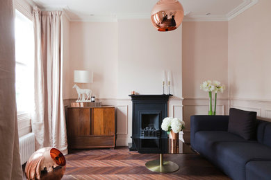 Imagen de salón actual de tamaño medio con paredes rosas, suelo de madera oscura, todas las chimeneas, marco de chimenea de metal y suelo marrón