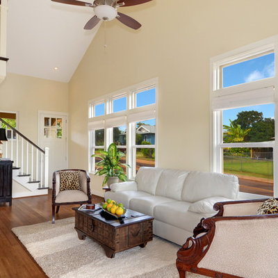 Inspiration for a mid-sized tropical formal and open concept medium tone wood floor and brown floor living room remodel in Hawaii with beige walls, no fireplace and no tv
