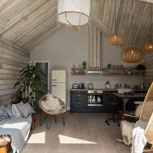 Medium sized world-inspired formal open plan living room in Sussex with beige walls, light hardwood flooring, a wall mounted tv and beige floors.