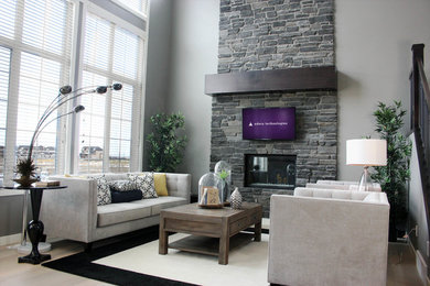 Inspiration for a large contemporary open concept light wood floor living room remodel in Calgary with gray walls, a standard fireplace, a stone fireplace and a wall-mounted tv