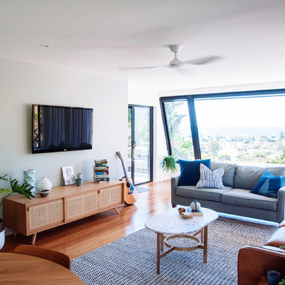 Example of a mid-century modern enclosed medium tone wood floor living room design in Gold Coast - Tweed with multicolored walls and a wall-mounted tv