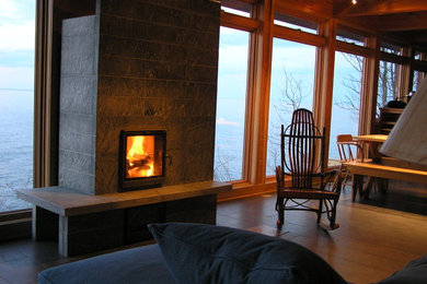 Example of a mid-sized mountain style enclosed light wood floor living room design in Minneapolis with a corner fireplace and a stone fireplace