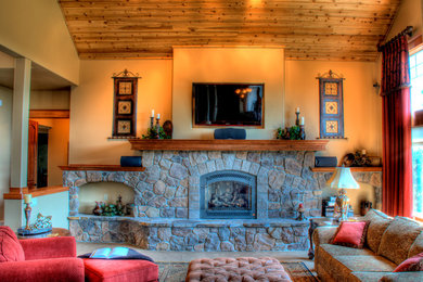 シアトルにある中くらいなトラディショナルスタイルのおしゃれなリビング (ベージュの壁、標準型暖炉、石材の暖炉まわり、壁掛け型テレビ) の写真
