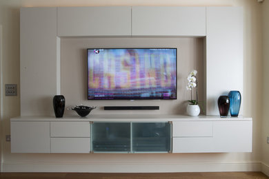 Inspiration for a medium sized contemporary living room in Kent with a built-in media unit, white walls and medium hardwood flooring.