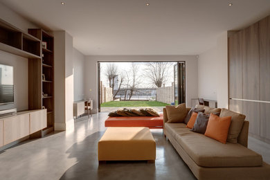 This is an example of a contemporary living room in Other with beige walls, concrete flooring, a built-in media unit and grey floors.
