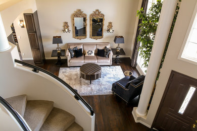 Modelo de salón abierto clásico renovado grande con paredes beige, suelo de madera oscura y suelo marrón