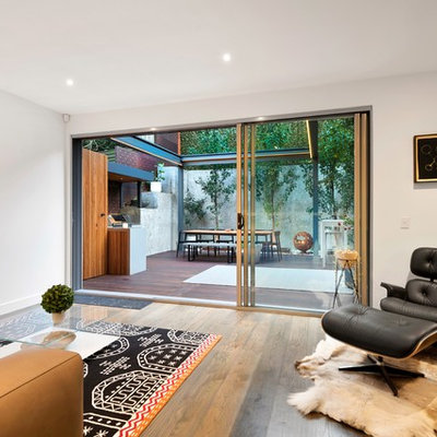 Example of a mid-sized trendy formal medium tone wood floor and brown floor living room design in Melbourne with white walls and a wall-mounted tv