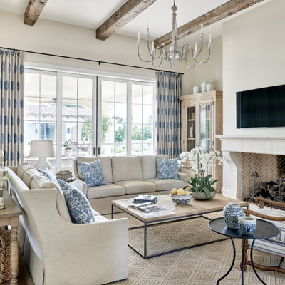 Inspiration for a large mediterranean open concept medium tone wood floor and beige floor living room remodel in Phoenix with beige walls, a standard fireplace, a plaster fireplace and a wall-mounted tv