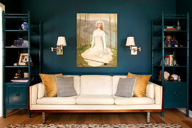 Imagen de salón bohemio sin televisor con paredes azules y suelo de madera en tonos medios