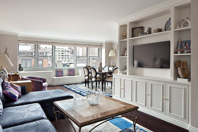 Diseño de salón para visitas abierto clásico grande con paredes blancas, suelo de madera oscura y televisor colgado en la pared
