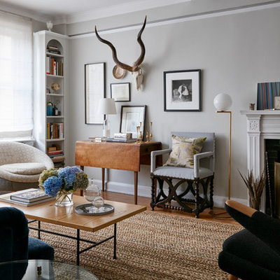 Living room - eclectic formal medium tone wood floor living room idea in New York with gray walls, a standard fireplace and a tile fireplace