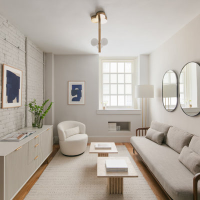 Living room - small contemporary formal and enclosed medium tone wood floor, brown floor and brick wall living room idea in New York with white walls, no fireplace and no tv