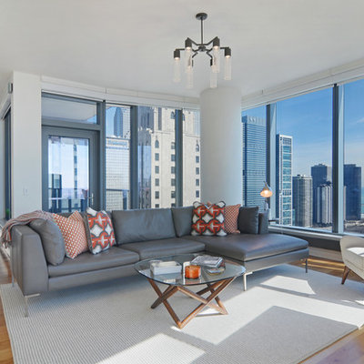 Trendy open concept medium tone wood floor living room photo in Chicago with white walls