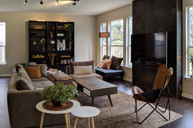 Foto de salón abierto minimalista grande sin chimenea con paredes negras, suelo de madera oscura y televisor colgado en la pared