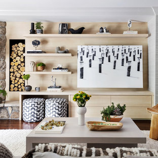 Eklektisk inredning av ett stort vardagsrum, med grå väggar, en öppen hörnspis, en spiselkrans i sten, ett bibliotek och mörkt trägolv