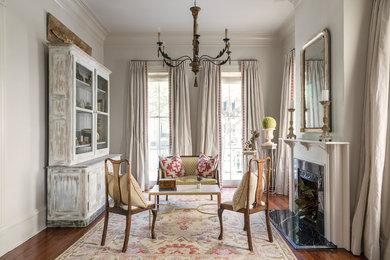 Example of a classic formal and enclosed dark wood floor and brown floor living room design in New Orleans with gray walls, a standard fireplace, a stone fireplace and no tv