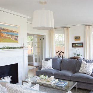 Immagine di un soggiorno stile marinaro di medie dimensioni e aperto con sala formale, pareti beige, pavimento in legno massello medio, camino classico, cornice del camino in intonaco, nessuna TV e pavimento marrone