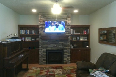 This is an example of a medium sized classic living room in Salt Lake City with light hardwood flooring, a standard fireplace and a stone fireplace surround.