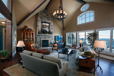 This is an example of a large eclectic formal open plan living room in Other with beige walls, dark hardwood flooring, a standard fireplace and a stone fireplace surround.