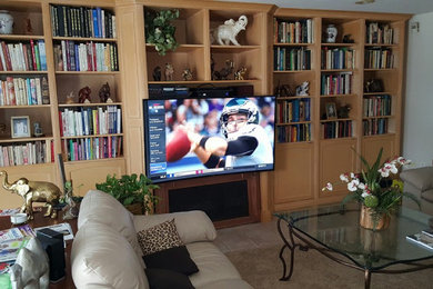 Example of a large living room design in Other with a media wall