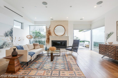 Großes, Fernseherloses, Offenes Modernes Wohnzimmer mit weißer Wandfarbe, hellem Holzboden, Kamin, gefliester Kaminumrandung und braunem Boden in Los Angeles