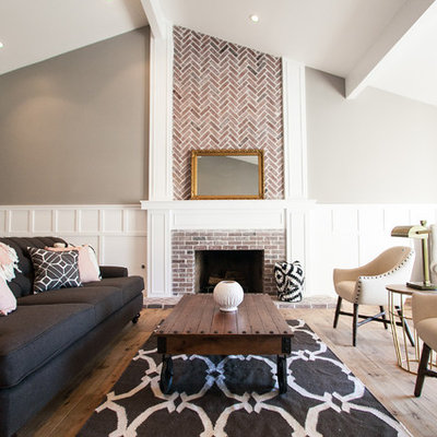 Mid-sized cottage open concept medium tone wood floor living room photo in Phoenix with gray walls, a standard fireplace and a brick fireplace